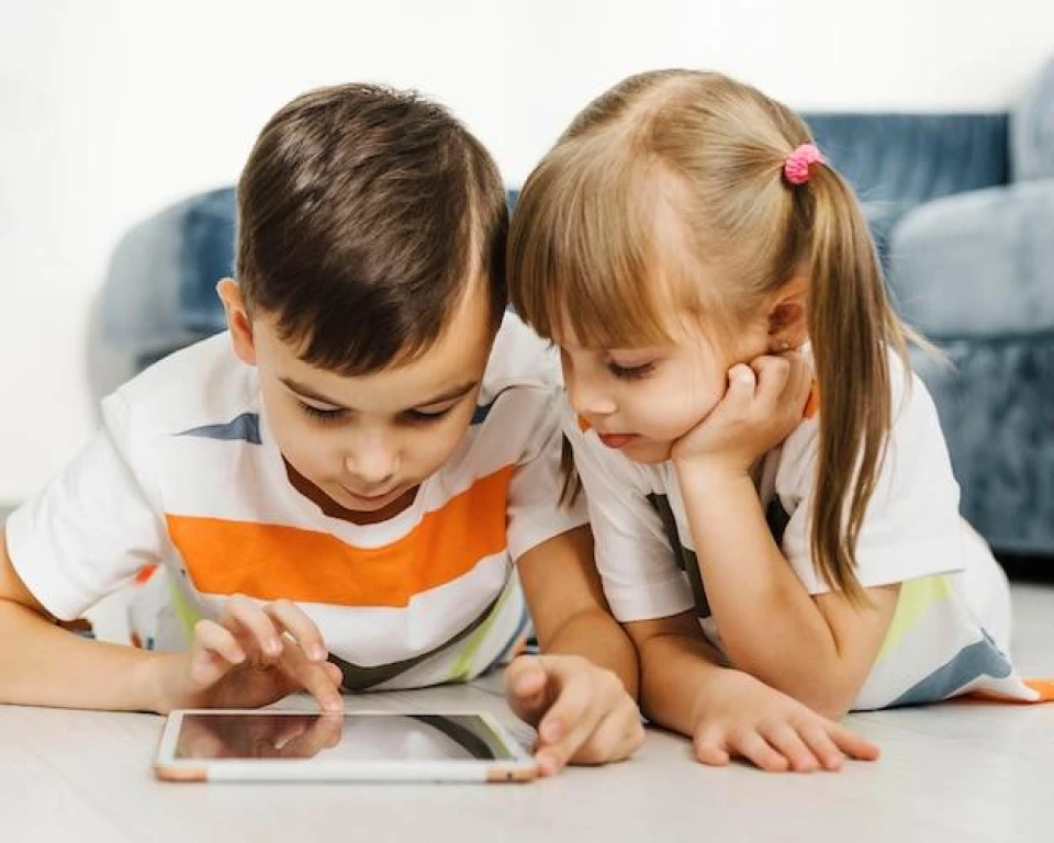 Front view siblings using a digital tablet