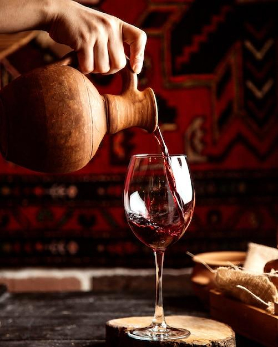 Free photo front view a man pours from a jug into a glass of red wine